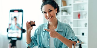 Woman influencer recording video while holding product